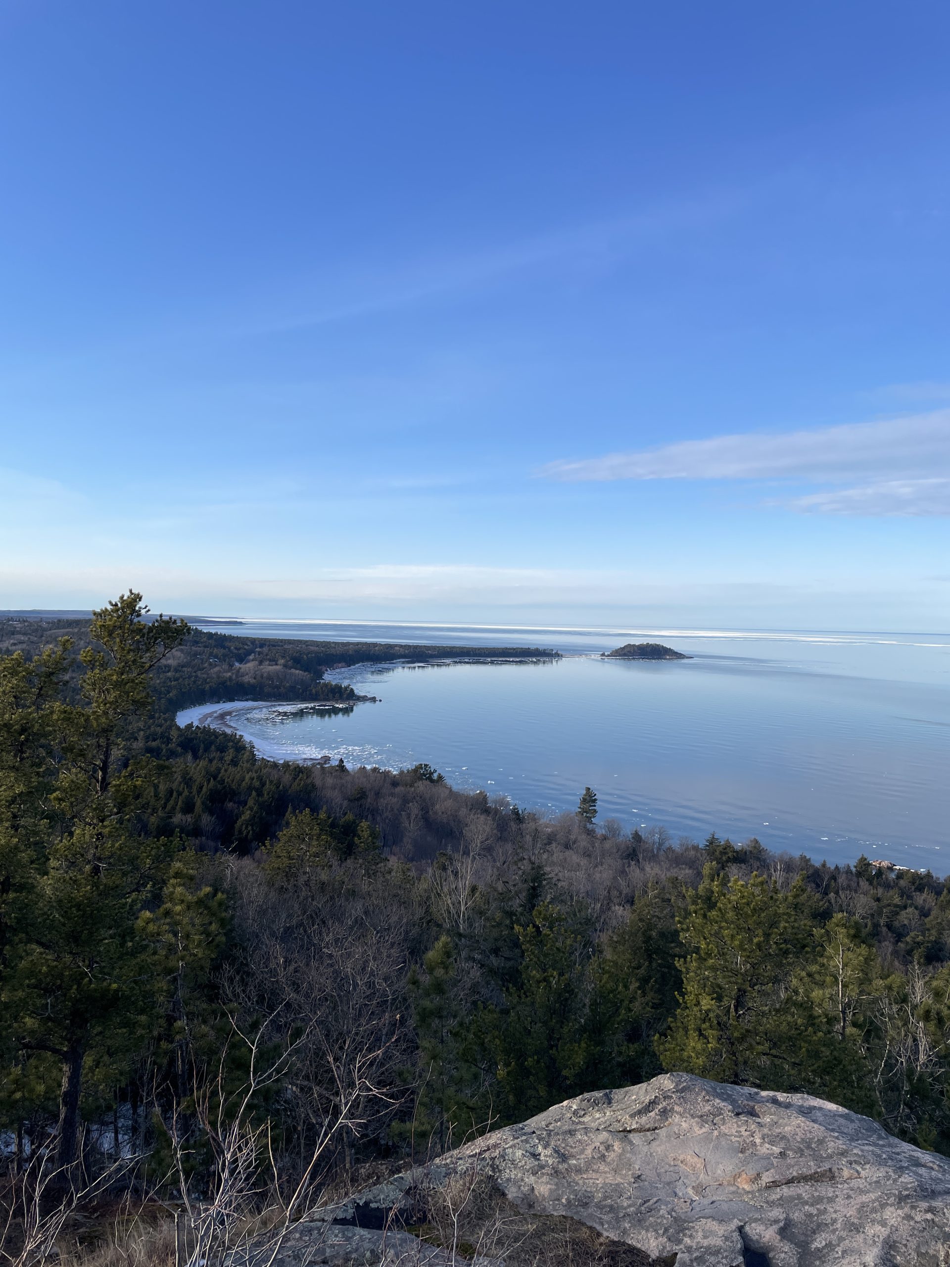 The view of Lake Superior and Little Presque Isle from an overlook on a clear blue-sky winter day. Photo taken by Jane Fitkin.